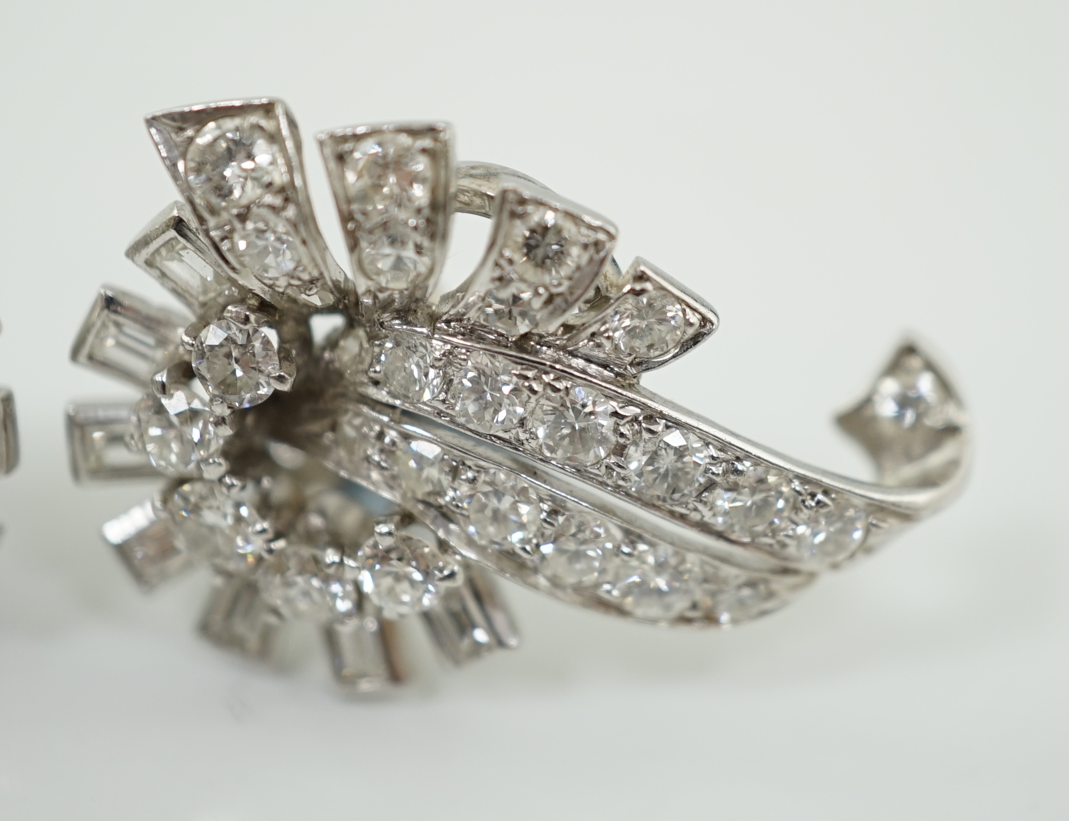 A pair of platinum and diamond cluster scroll ear clips